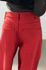 Jeans estilo baggy oversize de tiro medio en color rojo, con cinco bolsillos, trabillas para cinto y costuras decorativas marcadas en las piernas.