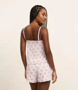 Conjunto de pijama de microfibra color rosa con estampado de ojos turcos. Incluye un top de breteles finos ajustables con volado en el bajo y un short con cintura elástica.