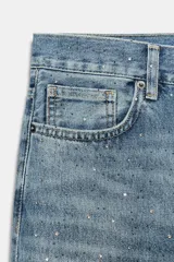 Jeans wide leg de tiro medio confeccionado en denim con efecto lavado, corte relaxed y diseño de pernera ancha. Cuenta con cinco bolsillos, trabillas en la cintura y cierre frontal con cremallera y botón metálico. Presenta aplicación de brillos en toda la prenda.