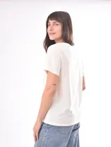 Remera negra de manga corta con estampado gráfico lineal en color blanco en el centro del pecho que incluye ilustraciones de frutas, copas brindando, una reposera y la inscripción "La Dolce Vita".