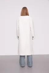 Tapado largo color marfil de poliéster con solapas, cierre con botones y corte holgado.