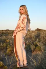 Pantalón de lino color nude con estampado de flores rojas y tigre blanco.