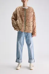 Campera reversible de calce relajado con diseño de animal print tipo leopardo, cierre frontal y bolsillos laterales.
