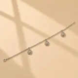 Pulsera de cadena de eslabones finos en plata 925, con tres dijes colgantes en forma de flor calada con un pequeño cristal central.