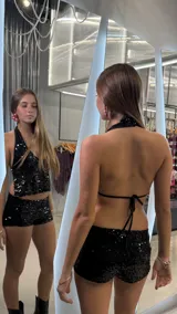 Short de tiro bajo confeccionado en tela con lentejuelas negras, de corte ajustado.