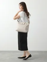 Cartera hobo grande Longchamp de la línea Le Pliage Xtra, confeccionada en cuero color gris claro, con solapa frontal con cierre de botón a presión y correa ajustable para el hombro.