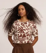 Blusa cropped de cuello redondo y manga corta, confeccionada en viscosa con elastano, con estampa de iconos playeros en tonos marrón sobre base beige y ribetes en las mangas.