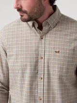 Camisa de manga larga confeccionada en franela de algodón orgánico, con diseño de cuadros pequeños en tonos beige, azul y rojo. Presenta cuello con botones, cierre frontal abotonado, bolsillo en el pecho con logo bordado y puños con botones.