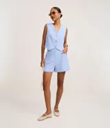 Short de cintura alta de estilo sastre en color celeste, con bolsillos laterales y tachuelas metalizadas.