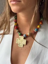 Collar con cuentas de colores y dije de cruz dorada.