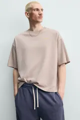 Camiseta boxy fit color gris topo, de cuello redondo y manga corta, con pequeño estampado frontal a contraste.