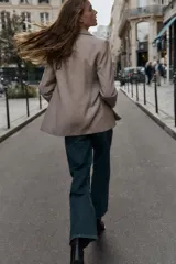 Blazer de corte sastrero confeccionado en tejido de lana con diseño de espiga. Presenta cuello con solapas, hombreras, cierre frontal con un botón y bolsillos delanteros con solapa.