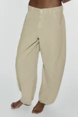 Jeans de tiro medio y corte barrel con diseño de perneras curvadas, tiro medio, trabillas para cinturón y cinco bolsillos. Presenta lavado clásico y costuras pespunteadas decorativas en la parte delantera.