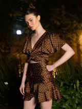 Minifalda marrón con lunares blancos, de corte ajustado con frunces y volados en el ruedo.