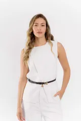 Conjunto de dos piezas color blanco compuesto por un chaleco sin mangas con diseño cruzado y un pantalón de vestir de corte recto. El chaleco incluye un cinturón fino negro con hebilla dorada que marca la cintura.