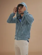 Campera con capucha de toalla color gris claro, con cierre completo y bolsillos frontales.