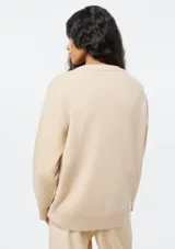 Buzo de punto de corte holgado, con cuello redondo acanalado y mangas largas con puños ajustados.