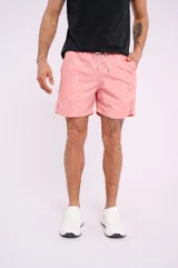 Short de baño color salmón con estampado de estrellas de mar blancas, cordón ajustable en la cintura y bolsillos laterales.