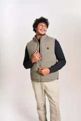 Chaleco puffer de corte regular, color beige, con cierre frontal y cuello alto. Presenta un diseño acolchado horizontal y logo bordado en el pecho.