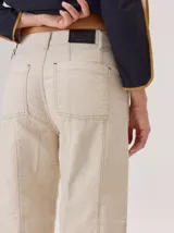 Pantalon de corte recto con costuras verticales decorativas en contraste color rojo. Presenta cintura con trabillas, cierre frontal con botón y bolsillos laterales.