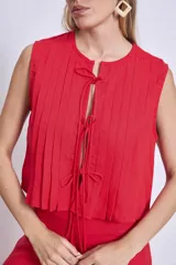 Blusa sin mangas color azul marino, con cuello redondo y detalle de tablas verticales en el frente. Corte holgado y corto.