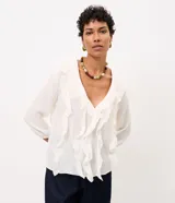 Blusa tipo bata de viscosa color blanco crudo, con cuello en V, volados frontales y mangas largas con puños elásticos. Confeccionada en tejido con textura crinkle de la marca Marfinno.