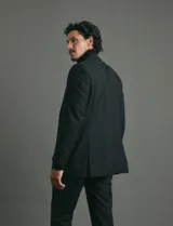 Traje de corte clásico compuesto por saco de dos botones y pantalón de vestir a juego. Diseño tradicional en color negro.