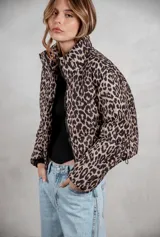 Campera puffer corta con estampado animal print, cuello alto y cierre frontal. Cuenta con bolsillos laterales y diseño acolchado.