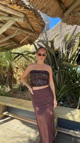 Top strapless de lentejuelas en color marrón oscuro con acabado brillante y ajuste al cuerpo.