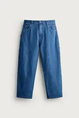 Jeans loose fit de tiro medio, confeccionados en denim de algodón color azul con efecto lavado. Presentan diseño de cinco bolsillos, bolsillo plastrón estilo carpintero en la pierna y cierre frontal con cremallera y botón.