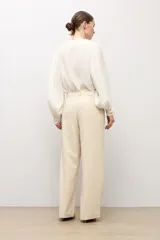Pantalón sastrero de corte recto y tiro medio, en color beige claro, con presillas para cinto y bolsillos funcionales.