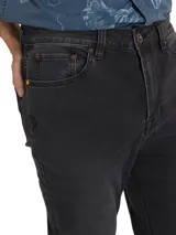 Jeans de corte slim fit en color negro, con diseño clásico de cinco bolsillos, cierre de cremallera y botón metálico.