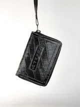 Mini billetera de cuero con textura efecto cocodrilo y cierre perimetral. Presenta un parche central con el logo de la marca grabado.