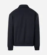 Campera masculina de corte boxy en color beige, con cuello inglés, cierre frontal de cremallera, mangas largas con puños elásticos y ruedo con elástico. Presenta bolsillos laterales y detalles de recortes en el diseño.