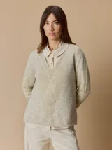 Buzo de lana con escote en V, diseño de rombos y detalles en hilo metalizado. Presenta mangas largas y corte holgado.