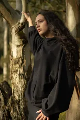 Canguro negro oversize de algodón, con capucha amplia, cuello alto integrado y ruedo ajustable con tancas.