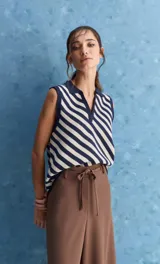 Chaleco tejido de punto con diseño de rayas diagonales en color marrón y beige, cuello polo y escote en V profundo.