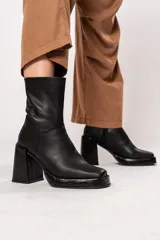 Bota de caña media color negro, de cuero, con horma cuadrada, taco geométrico con textura símil cocodrilo y plataforma.