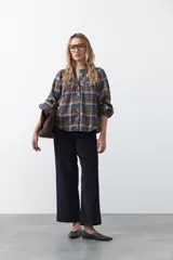 Pantalón de pana color marrón chocolate, de corte recto con bolsillos laterales y cierre frontal.