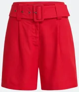 Short rojo de lino con cintura alta, cinturón con hebilla cuadrada forrada, pliegues delanteros y dos bolsillos laterales.