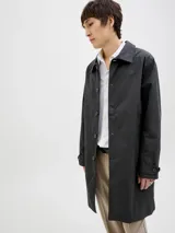 Campera tipo trench liviana de corte recto y largo medio, color negro, con cuello camisero, cierre frontal de botones y puños ajustables con trabilla.