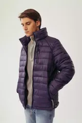 Campera puffer de diseño acolchado en color azul oscuro, con cuello elevado, cierre frontal completo y bolsillos laterales con cierre. Incluye un bolsillo adicional en el pecho y capucha oculta.