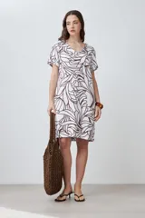 Vestido corto de lino color blanco con estampa abstracta en color chocolate, escote en V y mangas cortas.