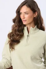 Buzo tejido combinado de color beige, con cuello alto, medio cierre metálico y puños y ruedo acanalados en tono tostado.
