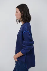 Buzo reversible de tejido de punto con diseño de trenzas, cuello redondo y mangas largas. Presenta una combinación de colores en contraste, con un lado en violeta y el otro en marrón oscuro.