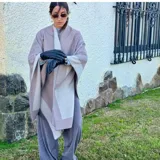 Ruana color beige con borde gris.