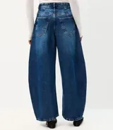 Pantalón barrel en jean de tiro alto con calce amplio y botamanga levemente afinada, de color azul, con recortes laterales, pespuntes contrastantes y bolsillos funcionales.