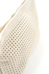 Neceser de diseño texturizado en tono beige, con cierre superior y una práctica tira de mano trenzada en blanco y negro con detalles oscuros.