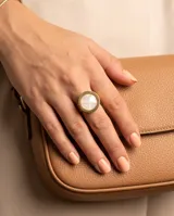 Anillo de acero con baño de oro, con diseño circular y centro de nácar.