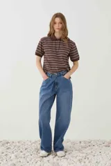 Jean relaxed de tiro medio y pierna amplia levemente curva, confeccionado en denim con efecto lavado. Cuenta con cinco bolsillos, presillas para cinturón y cierre frontal con botón.